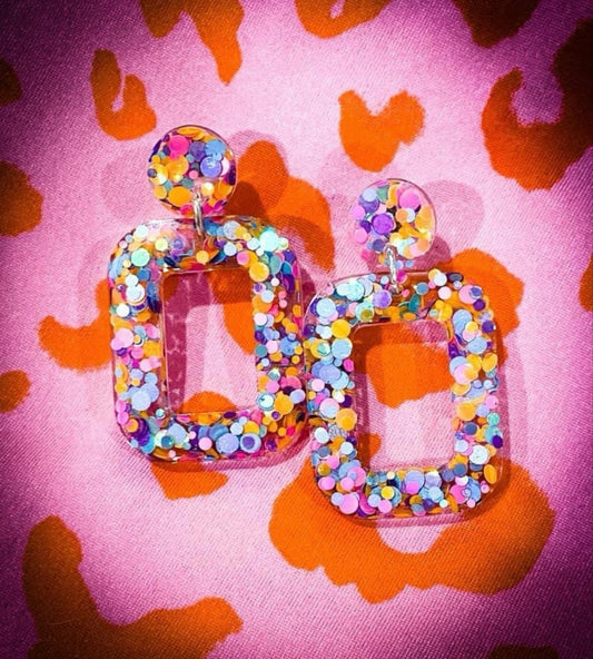 Earrings on an orange and pink background.