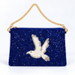 A royal blue beaded clutch bag featuring a large white beaded dove motif on the front, a gold-tone chain shoulder strap, and a gold zipper closure, set against a plain white background.