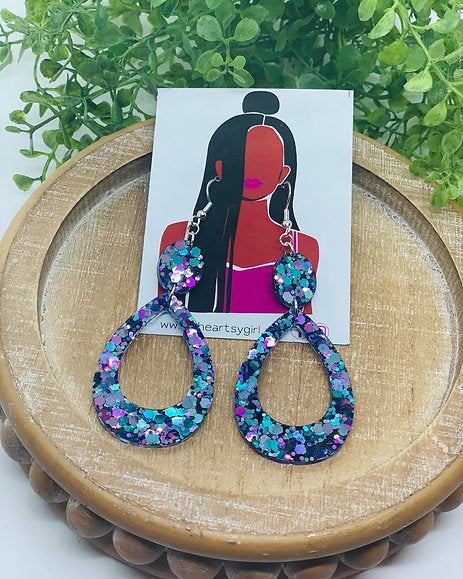 Blue dangling earrings named ‘3/17 Special,’ featuring intricate design with both metals intertwined, creating a unique and elegant look.
