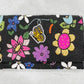 Beaded clutch with colorful floral and butterfly designs on a gray background