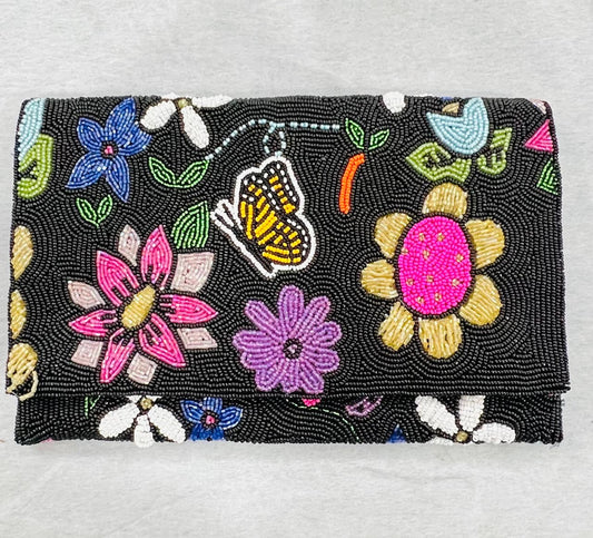 Beaded clutch with colorful floral and butterfly designs on a gray background