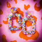 Earrings on an orange and pink background.