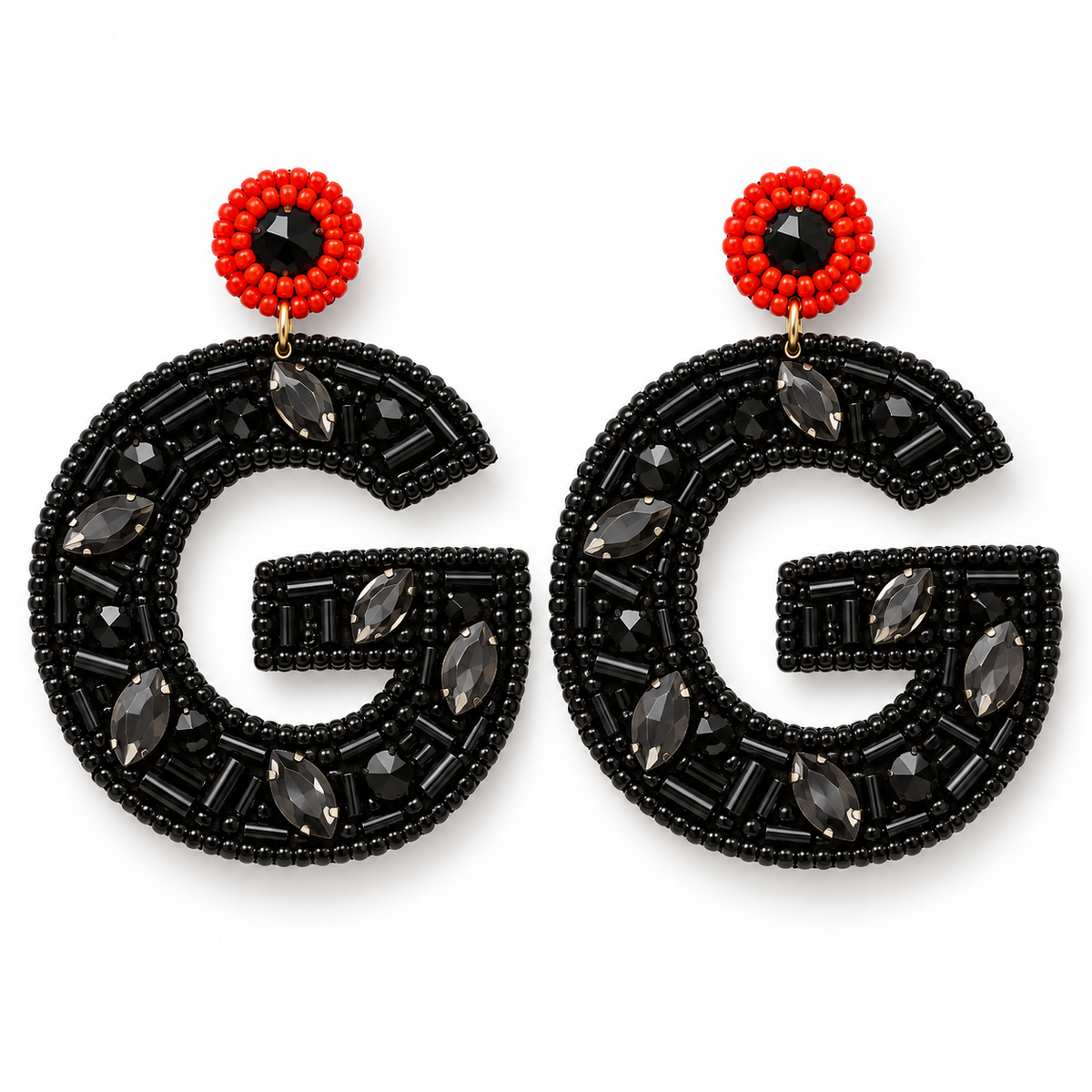 A pair of statement earrings featuring a large black beaded letter 'G' adorned with dark gray faceted marquise and oval crystals, topped with a red beaded circle and a central black faceted gemstone.