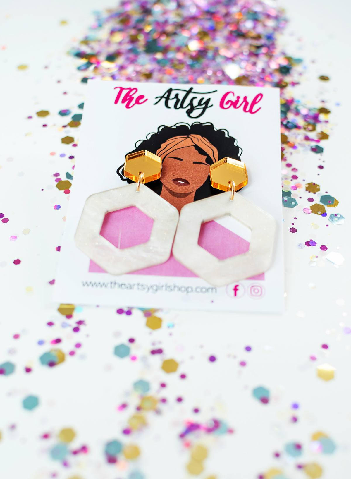 Ivory and gold earrings against an card