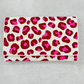 Pink and red spotted hand-beaded clutch purse on a neutral background showing detailed beadwork and fold-over design.