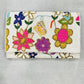 Embroidered clutch with floral and butterfly design on a gray background