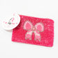 Close-up picture of a pink bow coin purse. 