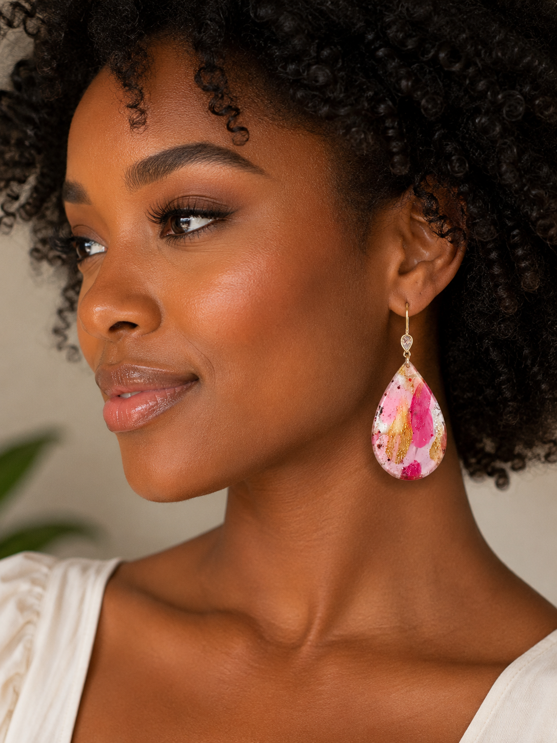 Woman wearing a colorful teardrop earring with a blurred background
