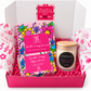 Open pink gift box containing a floral Sparkle Energy Journal, matching affirmation cards, and a Prosecco & Peaches candle.