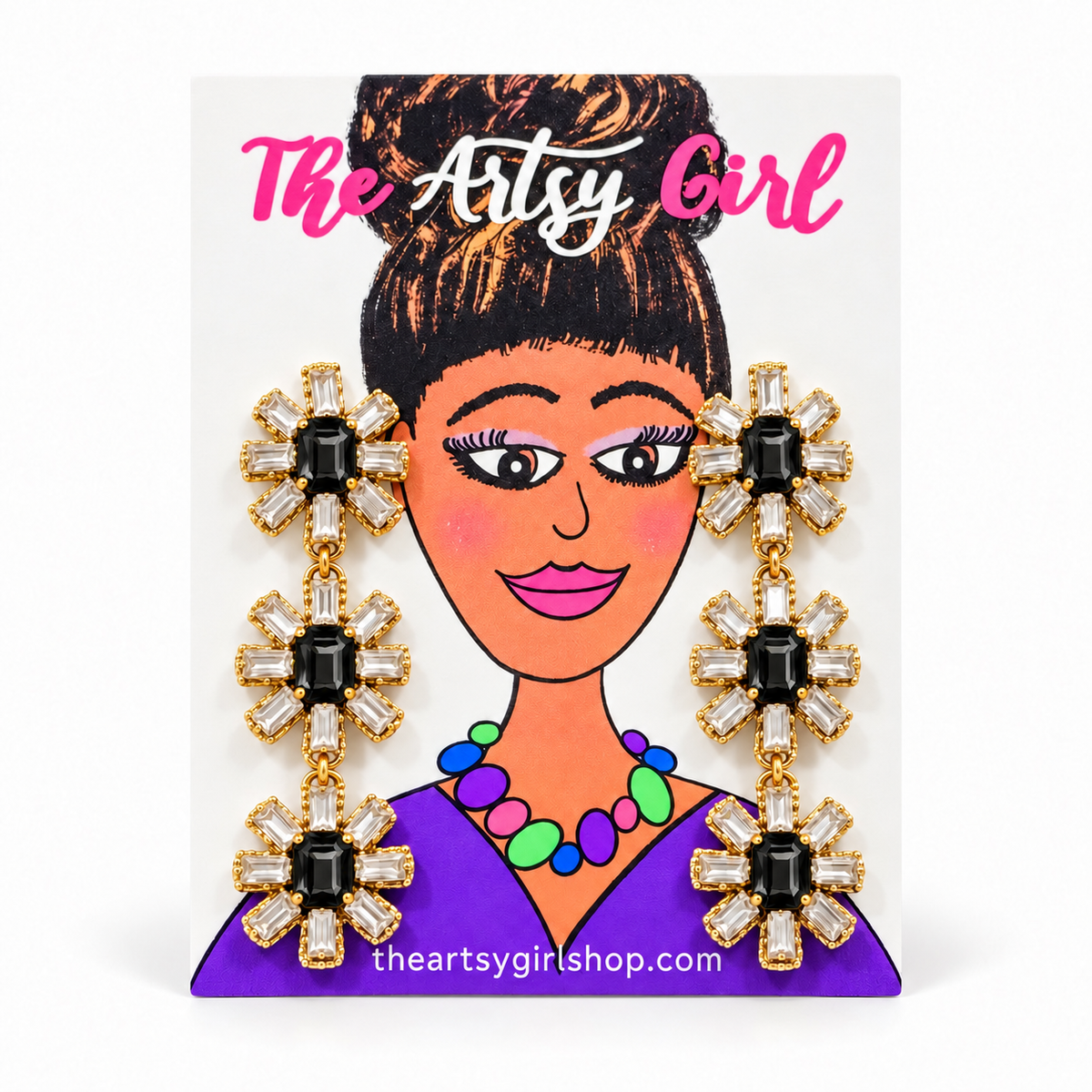 Three-tier floral earrings with black center stones, clear crystal petals, and gold settings on an Artsy Girl card.