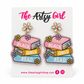 Pink, yellow, and blue book-stack earrings reading “Black Girls Read,” with crystal flower tops, on an Artsy Girl card.