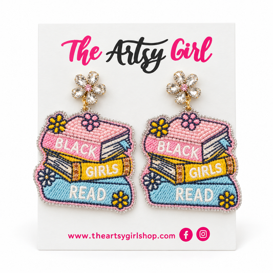 Pink, yellow, and blue book-stack earrings reading “Black Girls Read,” with crystal flower tops, on an Artsy Girl card.