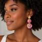 Woman wearing colorful earrings with a neutral background