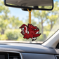 Beaded Gamecock charm in garnet, black, and silver hanging from a car’s rearview mirror by a gold cord.