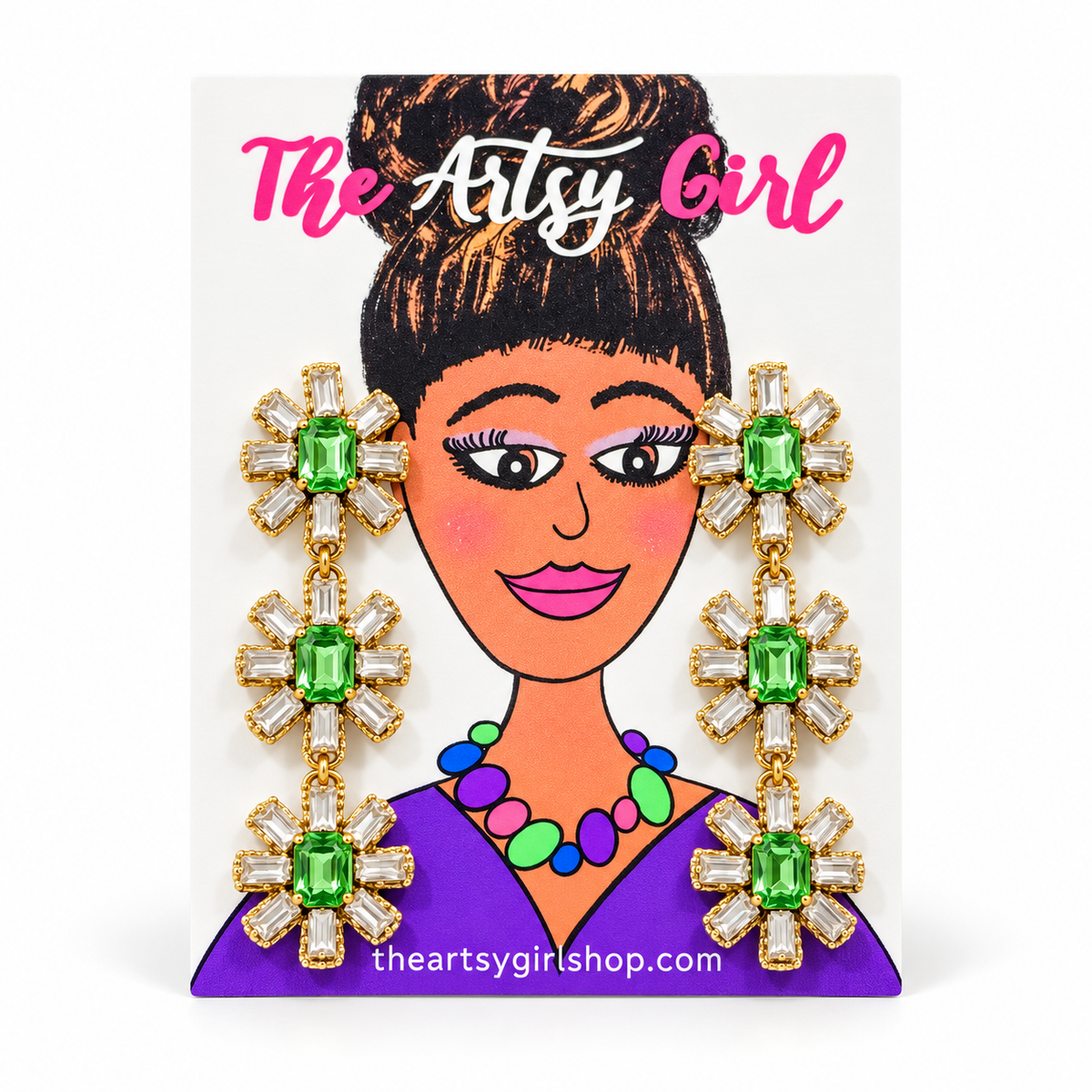 Three-tier floral drop earrings with green center stones, clear crystal petals, and gold settings on an illustrated Artsy Girl card.