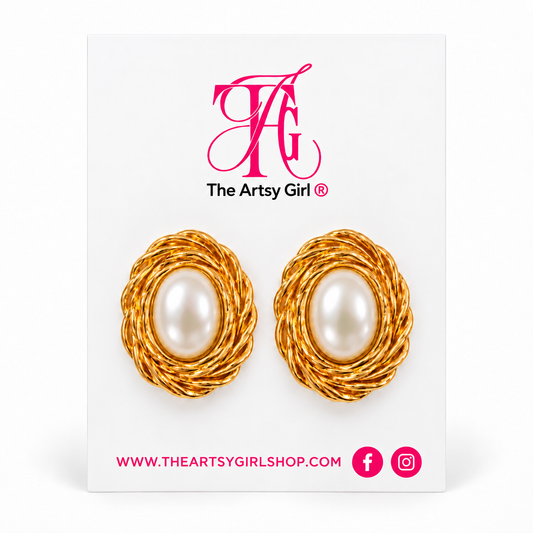 Oval pearl stud earrings with textured gold surrounds displayed on The Artsy Girl card.
