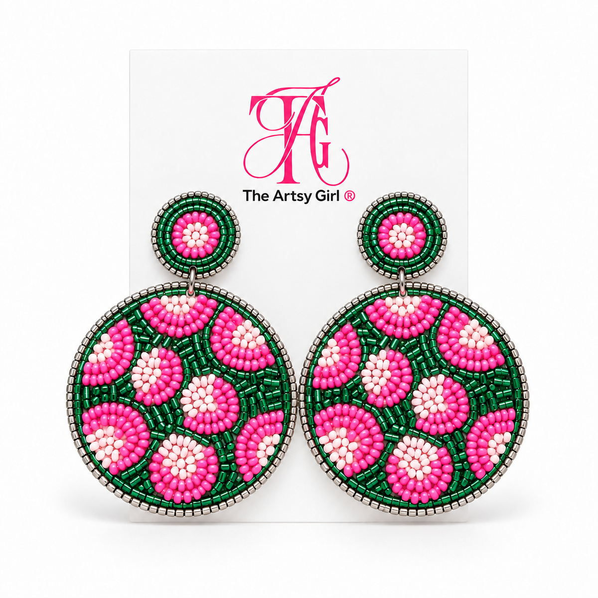 Round pink and green beaded leopard earrings with silver edging displayed on The Artsy Girl card.