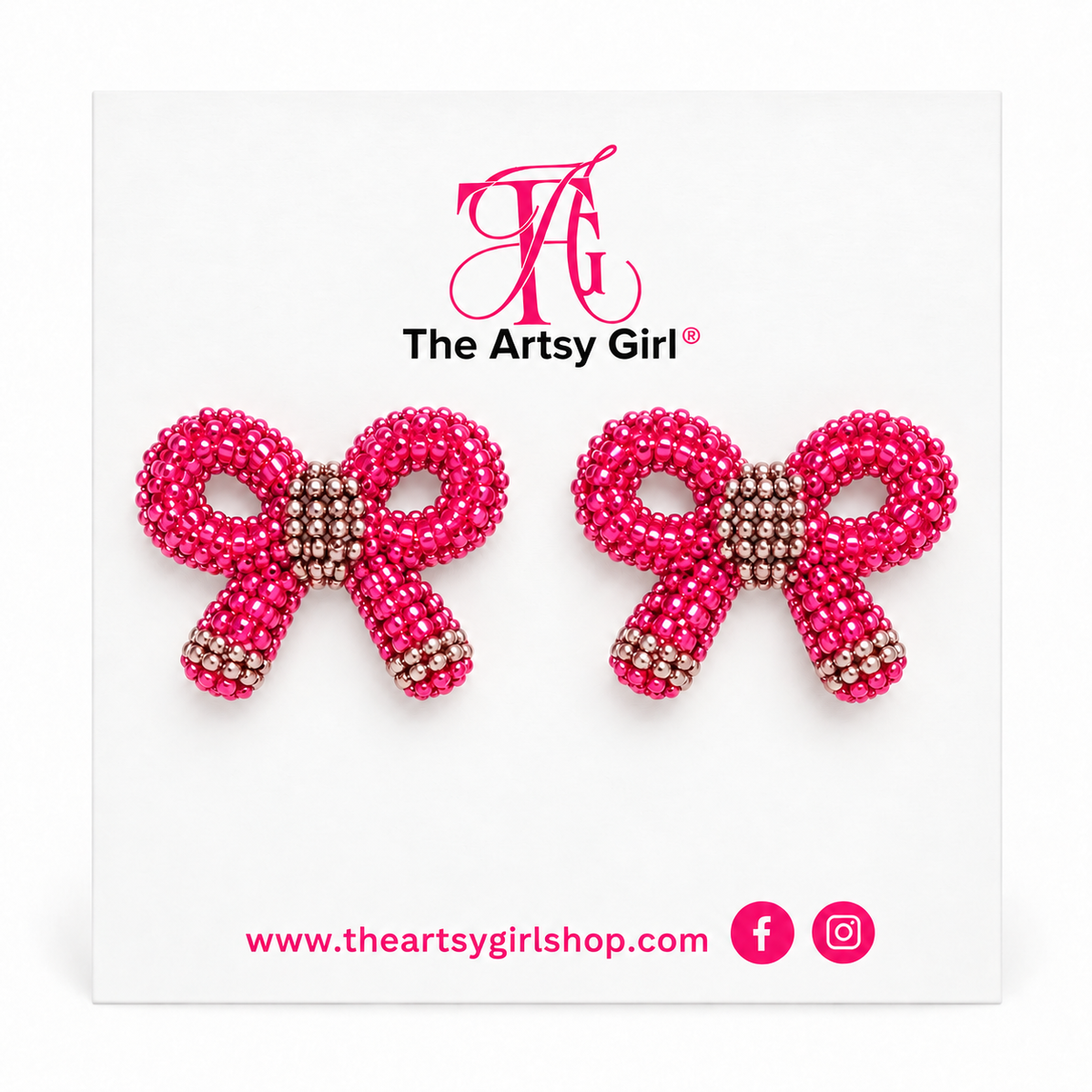 A pair of pink beaded bow stud earrings displayed on a white backing card. The backing card features the pink 'The Artsy Girl' logo at the top and the website URL along with social media icons at the bottom.