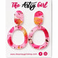 Pair of pink and orange marbled earrings on a 'The Artsy Girl' branded card.