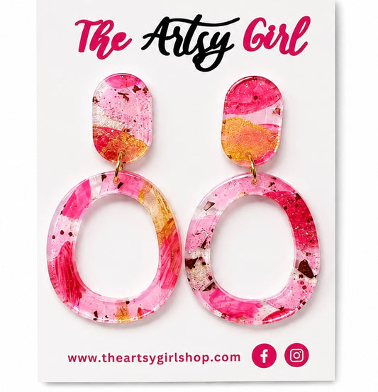 Pair of pink and orange marbled earrings on a 'The Artsy Girl' branded card.